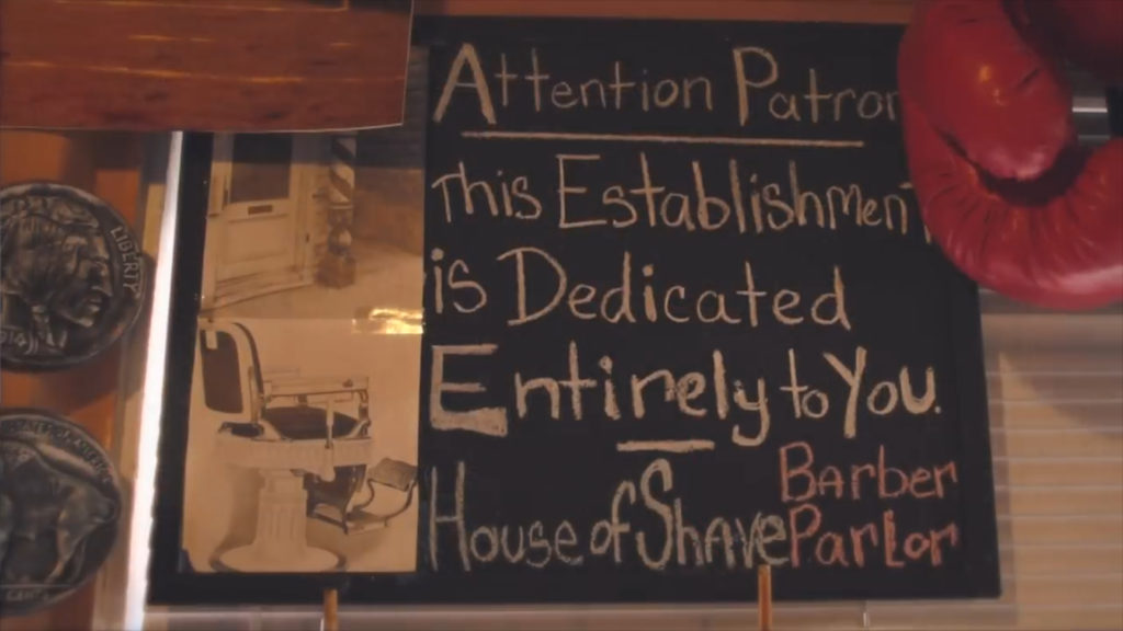 Sign In The House Of Shave Barber Parlor reads "Attention Patrons: this establishment is dedicated entirely to you - House of Shave Barber Parlor"